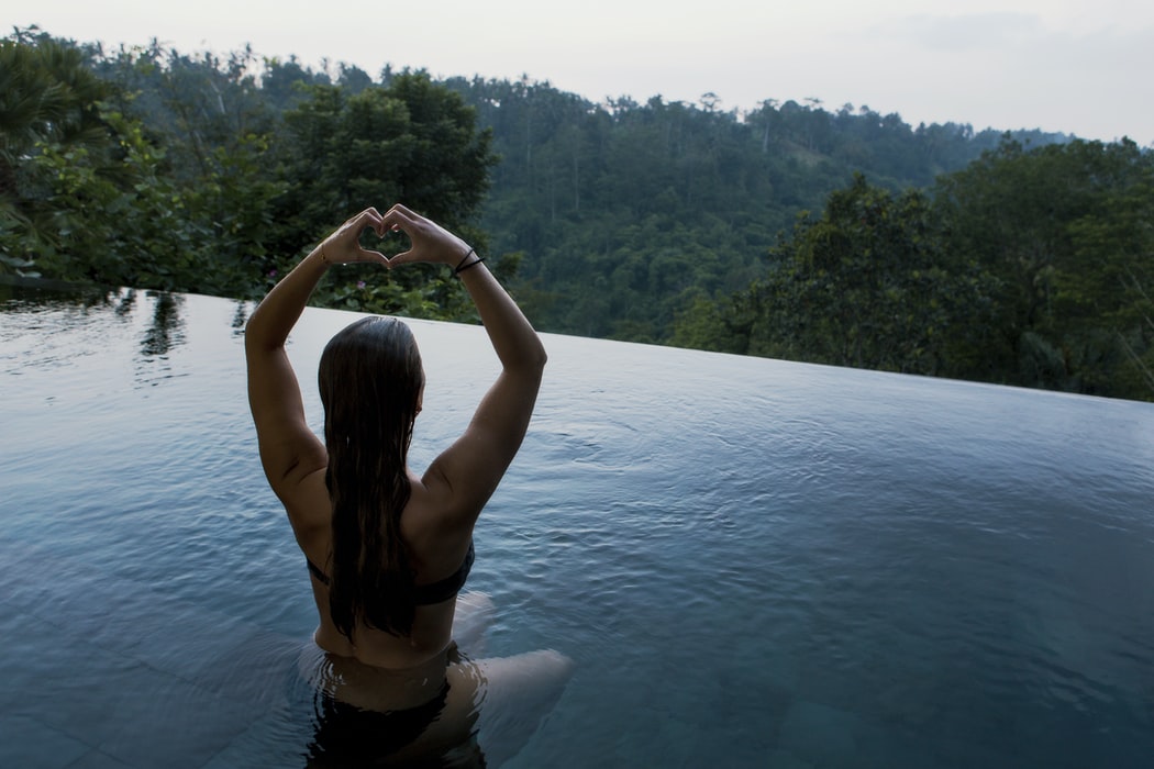 A woman meditating in a clean hot tub with a view