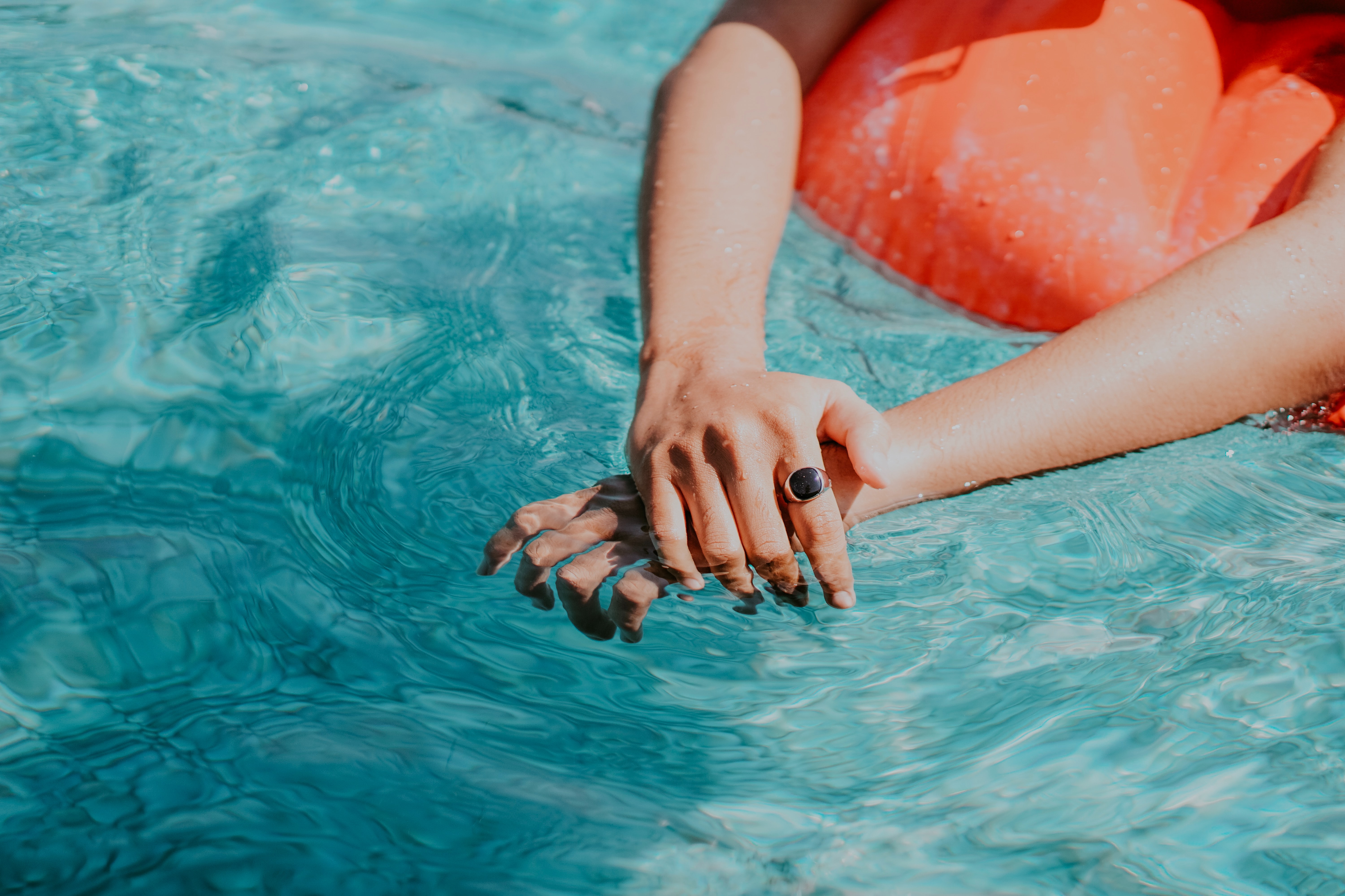 A woman’s hands in pool water