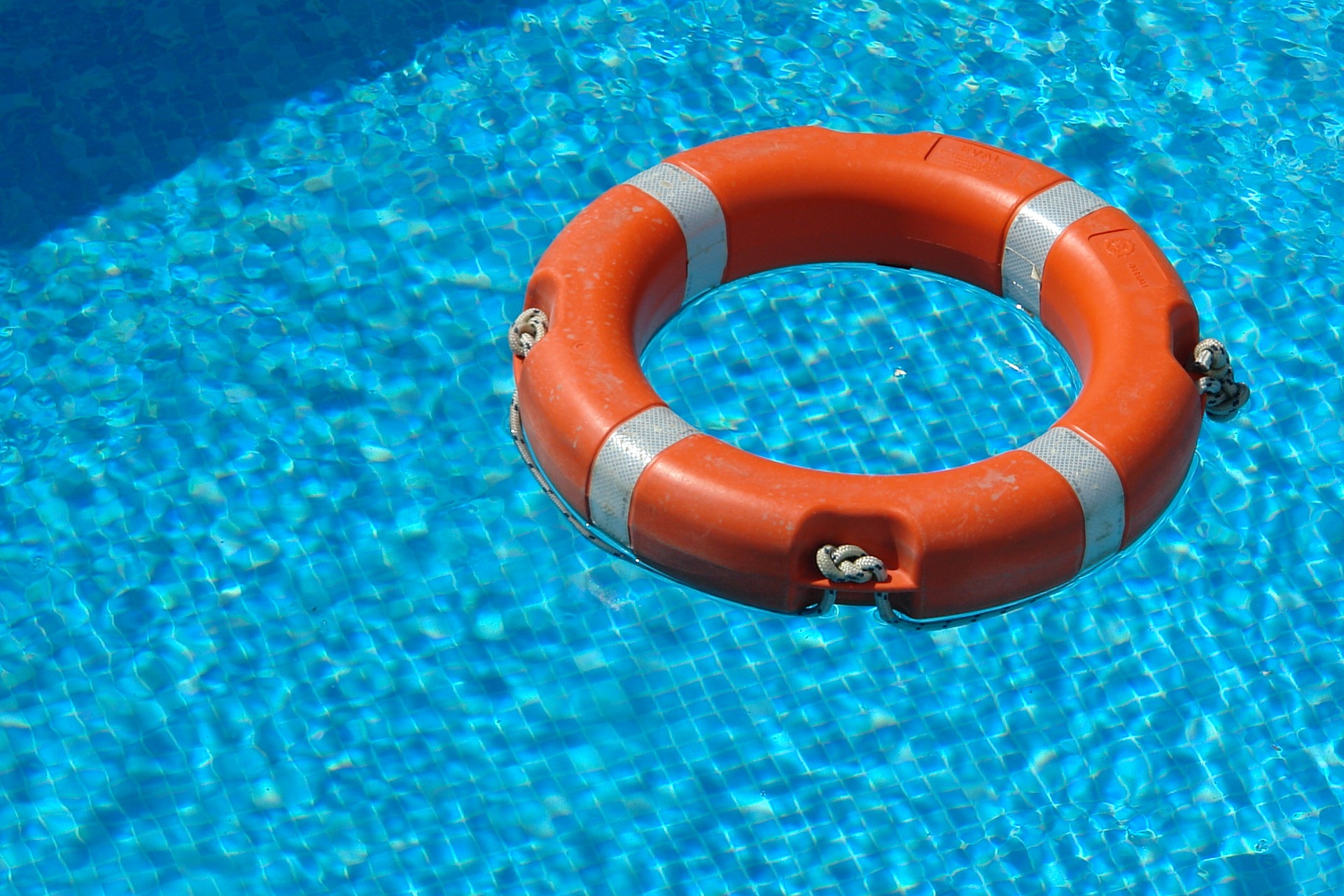 An orange lifesaver floating in a pool
