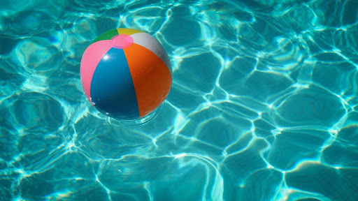 A swimming pool with a colourful inflatable ball